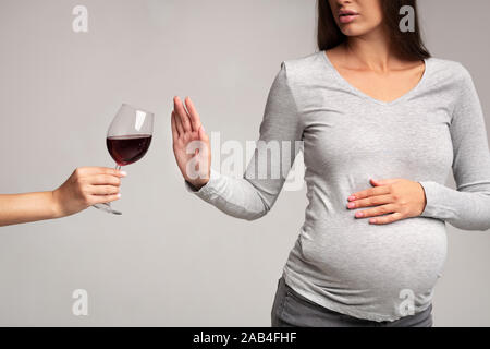 Dame enceinte Gesturing Stop pour verre de vin, Studio, Cropped Banque D'Images