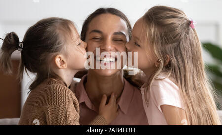 Mignon deux adorables petits filles s'embrasser sur les joues Maman heureuse Banque D'Images