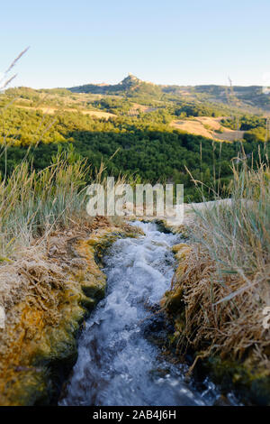 Les eaux thermales chaudes naturelles et vue sur Rocca d'Orcia de la colline spa village de Bagno Vignoni en Val d'Orcia Toscane Italie Banque D'Images