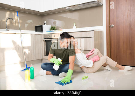 Jeune couple heureux est d'avoir reste après avoir fait le nettoyage à la maison. Banque D'Images