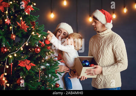 Beau couple avec boy decorating holiday tree Banque D'Images