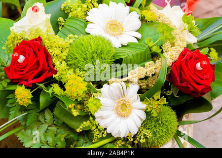 Arrangement de mariage pour le dîner en blanc avec de belles fleurs et bougies rouge Banque D'Images