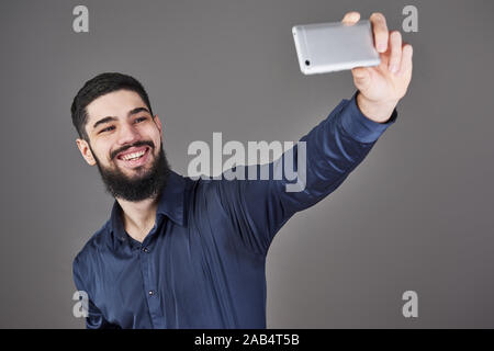 Happy smiling beau jeune homme barbu selfies rendant Banque D'Images