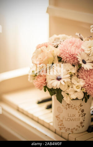 Bouquet de fleurs dans une belle boîte sur un piano blanc. Bouquet d'asters, hortensias et marguerites. Bouquet de mariée. Banque D'Images