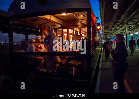 Passagers sont assis dehors sur l'air libre une partie de l'observation voiture car le Rovos Rail train de luxe voyagez entre Cape Town et de Pretoria en Afrique du Sud Banque D'Images