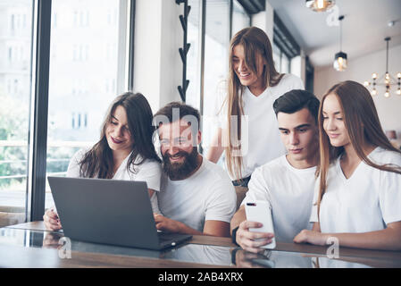Un groupe de jeunes avec des gadgets et un ordinateur portable organiser une séance de brainstorming et de communiquer les uns avec les autres. Le concept de l'élaboration d'une jeune entreprise Banque D'Images