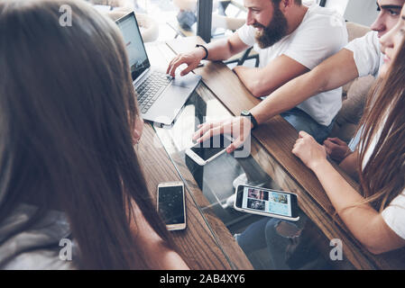 Un groupe de jeunes avec des gadgets et un ordinateur portable organiser une séance de brainstorming et de communiquer les uns avec les autres. Le concept de l'élaboration d'une jeune entreprise Banque D'Images