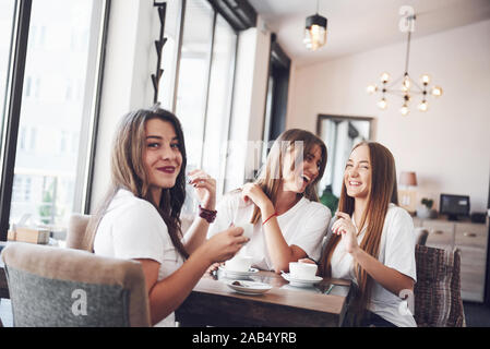 Les trois meilleures amies se sont réunis pour boire un café et de commérages. Les filles s'amuser et rire Banque D'Images