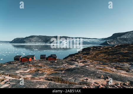 Image panoramique de la Camp Eqi Glacier Eqip Sermia à au Groenland. nature paysage avec lodge cabines. Soleil de minuit et ciel rose. Destination touristique Banque D'Images