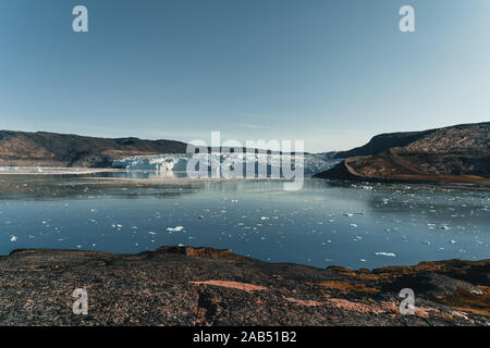 Image panoramique de la Camp Eqi Glacier Eqip Sermia à au Groenland. nature paysage avec lodge cabines. Soleil de minuit et ciel rose. Destination touristique Banque D'Images