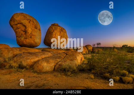 Devils Marbles emblématique : les oeufs de serpent mythique avec pleine lune sur ciel crépusculaire. Karlu Karlu est l'une des merveilles naturelles les plus célèbres Banque D'Images