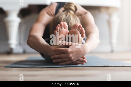 Les jeunes qui s'étend sur le tapis de sport balerine avant l'exercice Banque D'Images