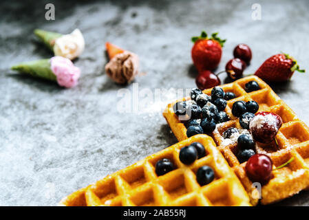 Fond d'aliments sucrés et savoureux avec des fruits rouges et des gaufres, avec l'espace négatif pour la conception d'été. Banque D'Images