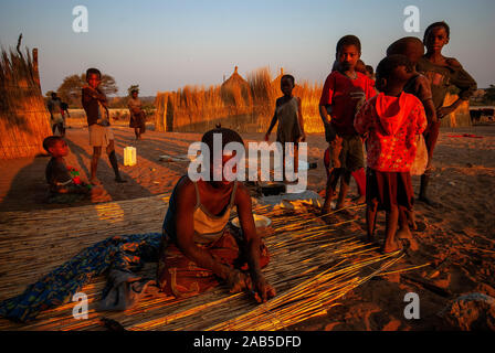 Habitants de la bande de Caprivi, femme la construction d'un mur en paille pour sa maison, en Namibie Banque D'Images