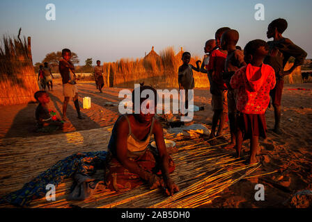 Habitants de la bande de Caprivi, femme la construction d'un mur en paille pour sa maison, en Namibie Banque D'Images