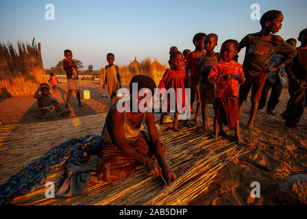 Habitants de la bande de Caprivi, femme la construction d'un mur en paille pour sa maison, en Namibie Banque D'Images