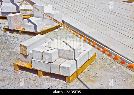 Palette en bois de nouvelles dalles de grès prêt à être monté dans un nouveau revêtement dans un site de construction en milieu urbain. Banque D'Images