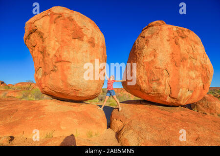 Woman enjoying touristique entre les rochers de granit plus iconiques dans Karlu-Devils Karlu Réserve de conservation des billes dans le Territoire du Nord, Australie Banque D'Images