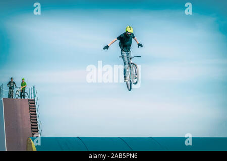 Les jeunes Bmx rider méconnaissable faisant un bike jump sur un tremplin. Sport extrême Banque D'Images