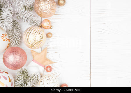 De la frontière du côté de Noël branches enneigées et vieux rose, d'or et des ornements blancs. Vue d'en haut sur un fond de bois blanc. Banque D'Images