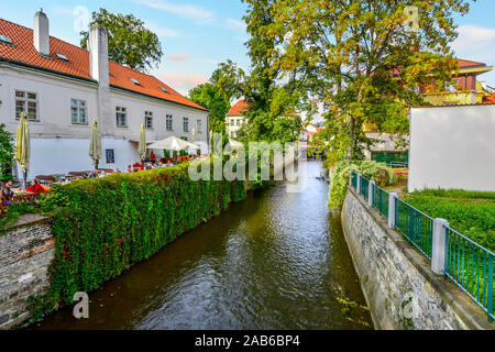 Les touristes et les habitants de dîner à la terrasse d'un café à côté d'un canal à proximité de la rivière Vltava dans la région pittoresque de l'île de Kampa à Prague, République Tchèque Banque D'Images