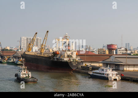 Ho Chi Minh Ville, Vietnam - 13 mars 2019 - Centre-ville de port sur Chanson fleuve Sai Gon au coucher du soleil. Thang Long cargo beign traitées à quai par son cran Banque D'Images