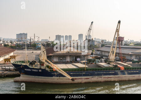 Ho Chi Minh Ville, Vietnam - 13 mars 2019 - Centre-ville de port sur Chanson fleuve Sai Gon au coucher du soleil. Huang Trieu 68 cargo général est déchargé par cran Banque D'Images