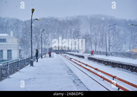 Kiev, UKRAINE - le 4 mars 2018 : la station de métro Dnipro plate-forme avec passagers train en attente et les travailleurs de la neige durant le nettoyage de neige, Kiev, Ukraine Banque D'Images