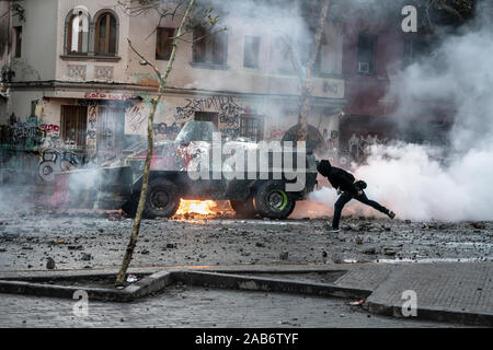 Un manifestant a lancé une bombe molotov sur un char de police lors d'affrontements entre la police et les manifestants à Vicuña Mackenna lors des dernières émeutes à Santiago Banque D'Images