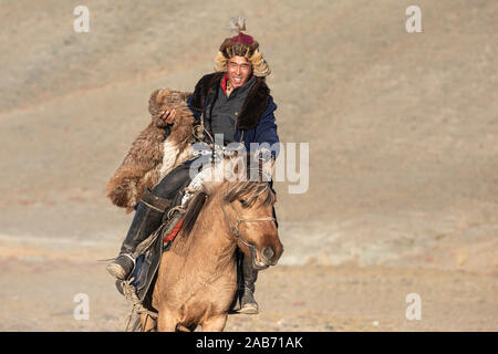 Les chasseurs eagle kazakhs prenant part à un match de lutte traditionnelle. Deux lutteurs à cheval commencer tirant sur une peau de mouton, celui qui le récupère, je Banque D'Images