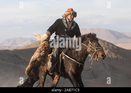 Les chasseurs eagle kazakhs prenant part à un match de lutte traditionnelle. Deux lutteurs à cheval commencer tirant sur une peau de mouton, celui qui le récupère, je Banque D'Images