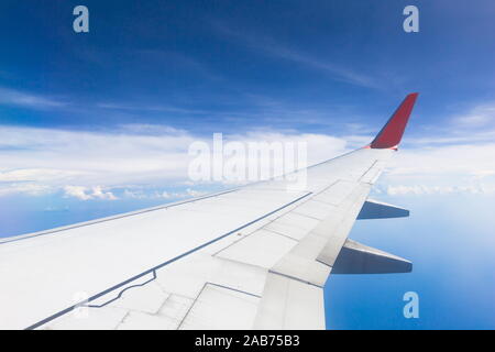 Nuages et ciel bleu comme vu à travers la vitre d'un avion. Banque D'Images