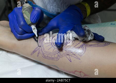 Close up machine à tatouer, l'homme de la création photo sur la main avec elle en studio de tatouage. Banque D'Images