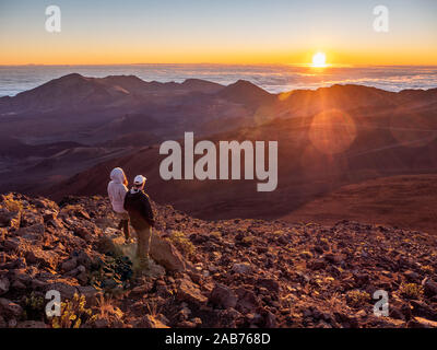 Homme et femme couple check out du lever du soleil sur le parc national de Haleakala sur Maui, Hawaii. Banque D'Images