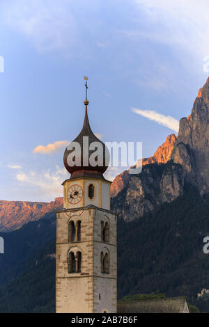 Paysages de Sunrise Eglise Saint Valentin sur une colline herbeuse avec vue sur pics accidentés de la montagne Schlern avec alpenglow en arrière-plan dans la vallée o Banque D'Images