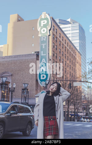 VPortland, Oregon - Nov 24, 2019 : femme d'origine asiatique posant devant un signe iconique dans le centre-ville de Portland portland Banque D'Images