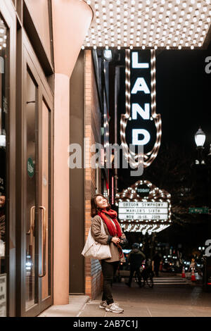 Portland, Oregon - Nov 16, 2019 : Asian female posing in front of Arlene Schnitzer Concert Hall de nuit Banque D'Images