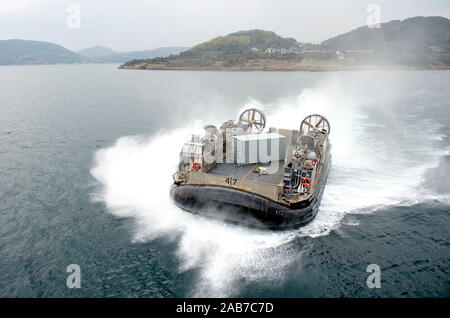 SASEBO, Japon (Janv. 24, 2013) Un landing craft air cushion (LCAC) s'approche de la porte arrière du navire d'assaut amphibie USS Bonhomme Richard (DG 6), de se joindre à elle sur un déploiement prévu. Le Bonhomme Richard Groupe amphibie est en déploiement dans la zone d'opérations de la 7e Flotte et prendront part à la formation d'intégration amphibie (ACI), et l'exercice de certification (CERTEX) et participera à la multi-nationale annuelle d'entraînement interarmées Gold Cobra. Banque D'Images