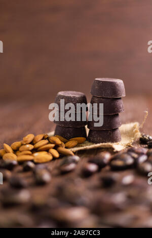 Chocolat artisanal entouré par les fèves de cacao sur bois Banque D'Images