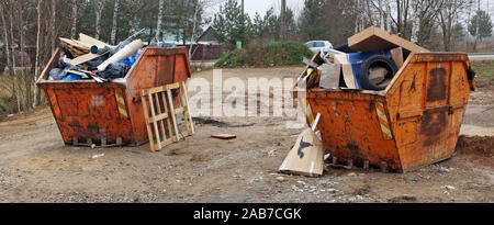 Couleur orange rouille écrasé des poubelles remplis de débris de construction, près de la route du village. Paysage urbain panoramique nuageux jour Novamber Banque D'Images