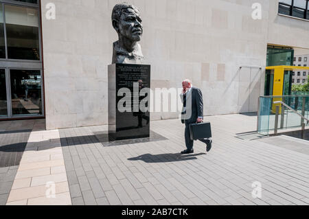 Buste en bronze de la statue du héros de la libération sud-africaine Nelson Mandela et homme d'affaires parlant sur téléphone portable, South Bank, Londres, Angleterre, Royaume-Uni. Banque D'Images