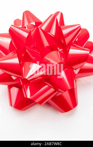 Close-up de grand cadeau rouge vif brillant dans bow sur fond blanc Banque D'Images