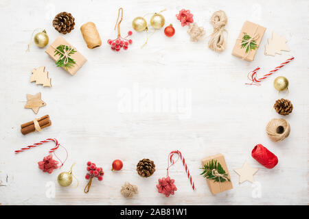 Noël arrière-plan de création d'objets divers, y compris des boîtes-cadeaux, des bâtons de cannelle, fruits décoratifs sur une table en bois blanc, copie espace au milieu, sur le tableau blanc, selective focus Banque D'Images