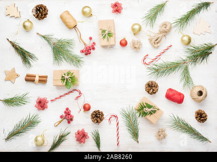 Noël arrière-plan de création d'objets divers, y compris des boîtes-cadeaux, des bâtons de cannelle, fruits décoratifs sur une table en bois blanc, copie espace au milieu, sur le tableau blanc, selective focus Banque D'Images