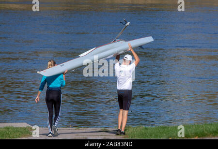 15 octobre 2019, Saxe, Meissen : Deux athlètes portent un bateau à rames pour les rives de l'Elbe. Photo : Jens Büttner/dpa-Zentralbild/ZB Banque D'Images