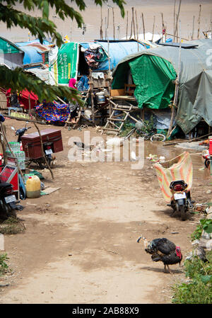 Route sale à travers les bidonvilles près du fleuve Mékong au Cambodge, l'Asie du sud-est. Banque D'Images