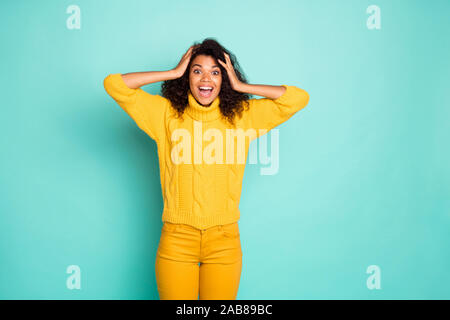 Le vendredi noir des ventes. Photo de la peau sombre incroyable dame tenant les mains sur la tête pense pas yeux porter des pantalons pull tricoté jaune bleu sarcelle isolés Banque D'Images