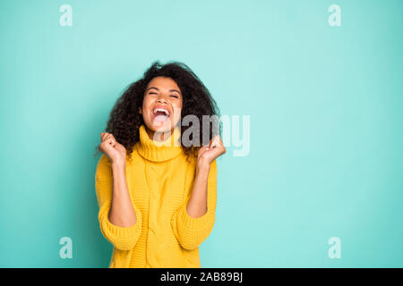 Photo de cool dark skin lady holding hands raised celebrating birthday minuit venant porter pull tricoté jaune bleu sarcelle élégante isolé couleur Banque D'Images