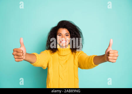 Photo de drôle de peau sombre dame holding hand l'humeur positive en augmentant à la fois le coup de porter des pantalons à la mode pull tricoté jaune bleu couleur sarcelle isolés Banque D'Images