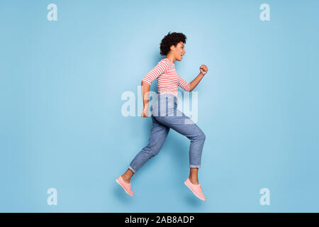 Profil de côté toute la longueur de la taille du corps photo de Happy cute positive assez belles amie portait un jeans denim chemise rayée chaussure running Banque D'Images